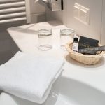 Ein Waschbecken mit einem Handtuch und Pflegeprodukten.