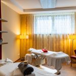 Latini_Massageraum_1 Ein Massage Raum mit zwei Liegen und einem Fenster mit einem Vorhang.