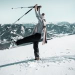 Schneeschuhwandern_mit Ausblick A person standing in the snow with hiking poles.
