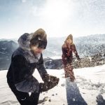 SpaßimSchnee_HotelLatini Two people throwing snowballs at each other.