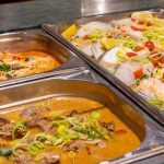 Latini_Abendbuffet_8 Three metal containers with food.