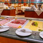 Latini_Frühstück_4 A breakfast buffet with plates and cutlery.