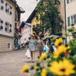 Shopping in Zell am See (c) Zell am See-Kaprun Tourismus_original A shopping street with people and flowers in the foreground.