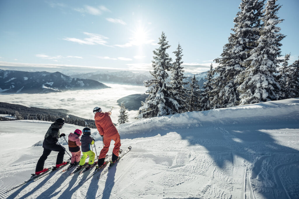 Familie beim Skifahren auf der Schmittenhöhe in Zell am See, mit Blick über das Nebelmeer